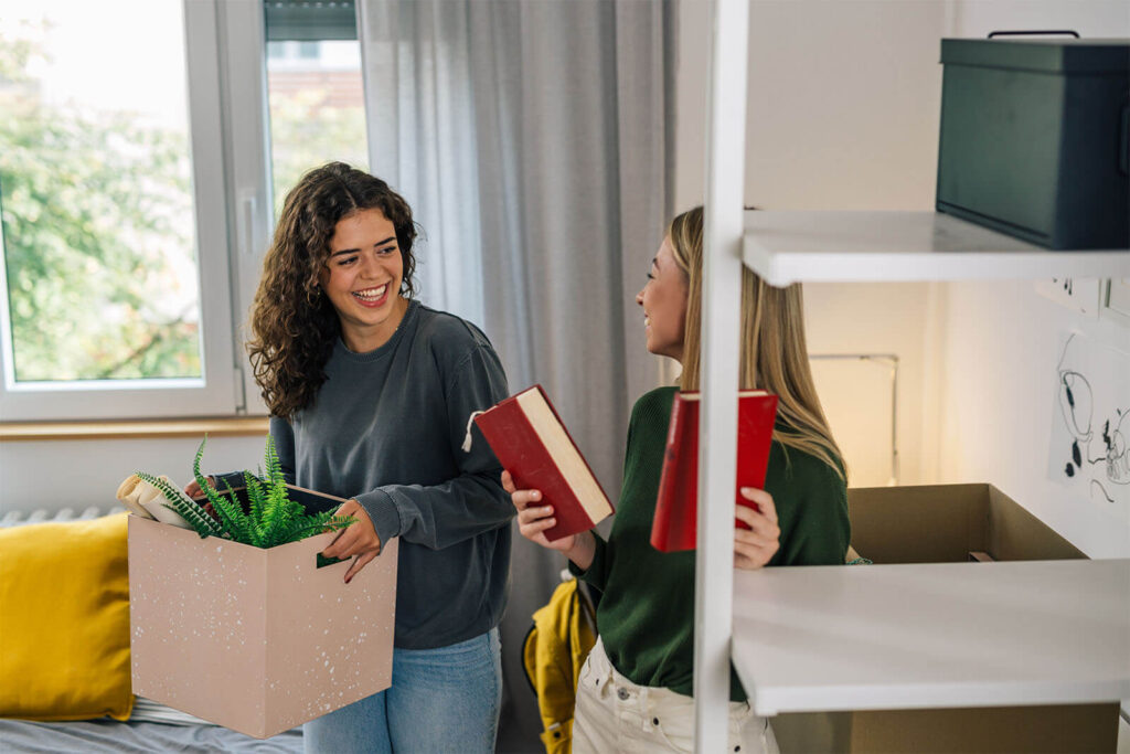 smiling students moving into new apartment